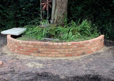 Brick wall around green garden
