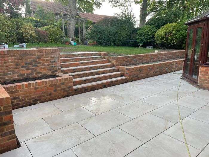 Patio in back garden leading to steps